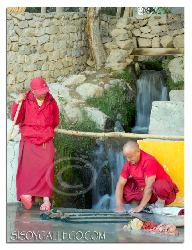 Monje lavando ropa encima de la acera