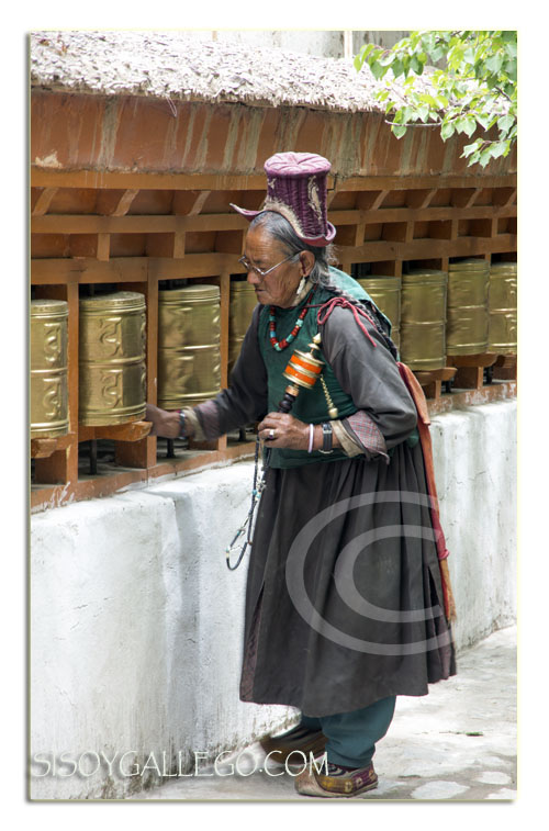 Típico atuendo de la zona y portando un rodillo de oración